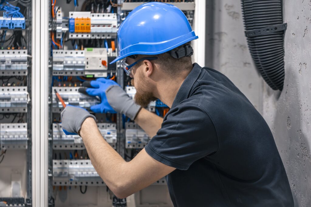 a male electrician works in a switchboard with an 2026 01 09 00 16 40 utc